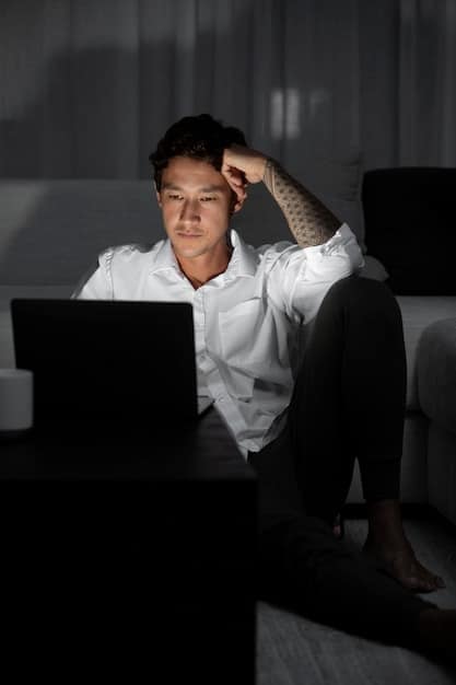 A person sitting alone in a dark room, looking distraught at a laptop screen filled with news articles and social media posts about them being 