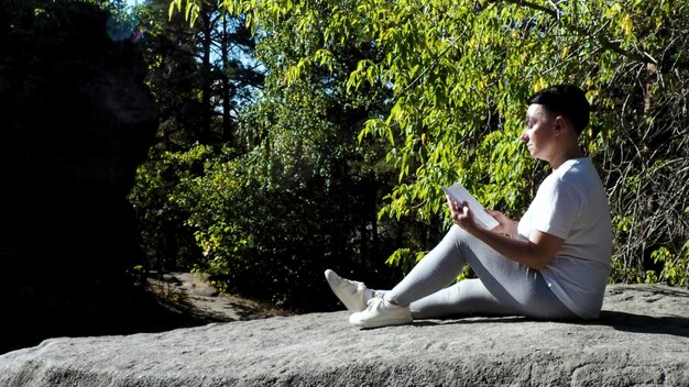 A person peacefully meditating in a park, with a smartphone turned off lying beside them, symbolizing taking a break from the digital world.