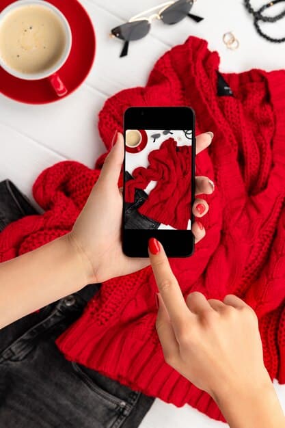 A close-up shot of a person's hands scrolling through a fashion drop calendar app on their smartphone, with blurred images of stylish clothing and accessories in the background.