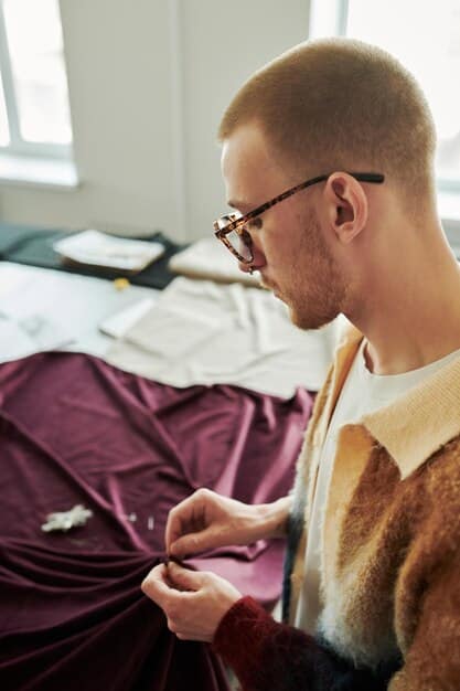A close-up shot of a skilled artisan hand-stitching a garment in a bright, airy workshop. Natural materials are visible, highlighting the craftsmanship and attention to detail in independent designer products.