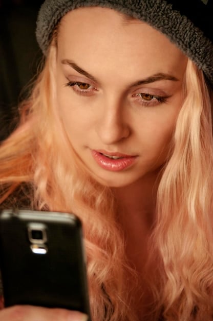 A close-up of a person's eyes intensely focused on a smartphone screen displaying the TikTok 