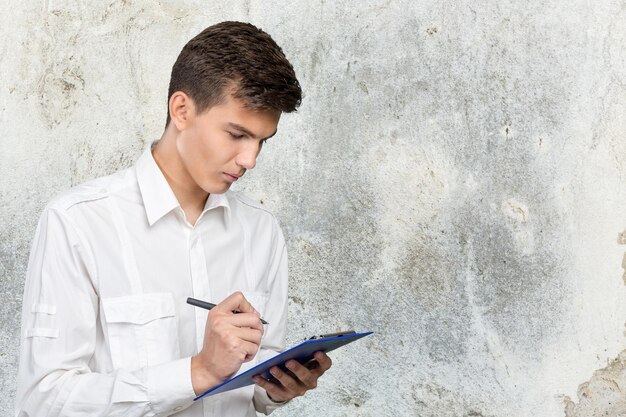 An image showing a person thoughtfully reviewing a document with a pen in hand, highlighting key points and making corrections. The setting suggests an office or study environment.